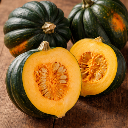 Acorn squash with one cut open on a wooden surface