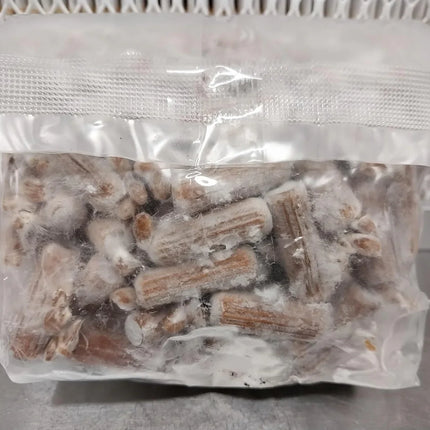 Clear plastic bag filled with small cylindrical objects on a textured surface.