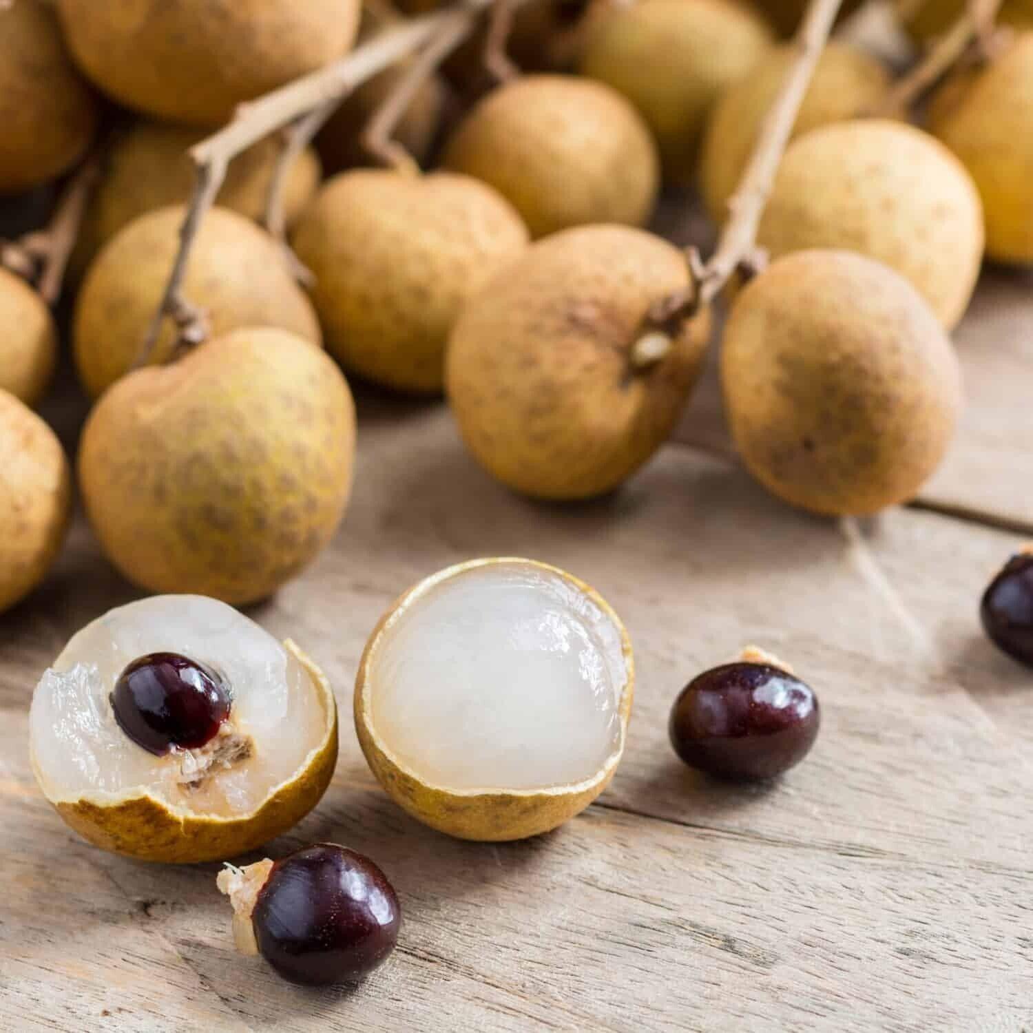 Whole and halved Longan “Dragon Eye” fruit showing translucent flesh and dark seed
